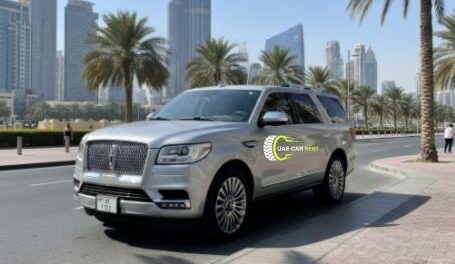 A realistic photograph of a silver Lincoln Navigator SUV parked on a sunny Dubai street with the Burj Khalifa and palm trees in the background.